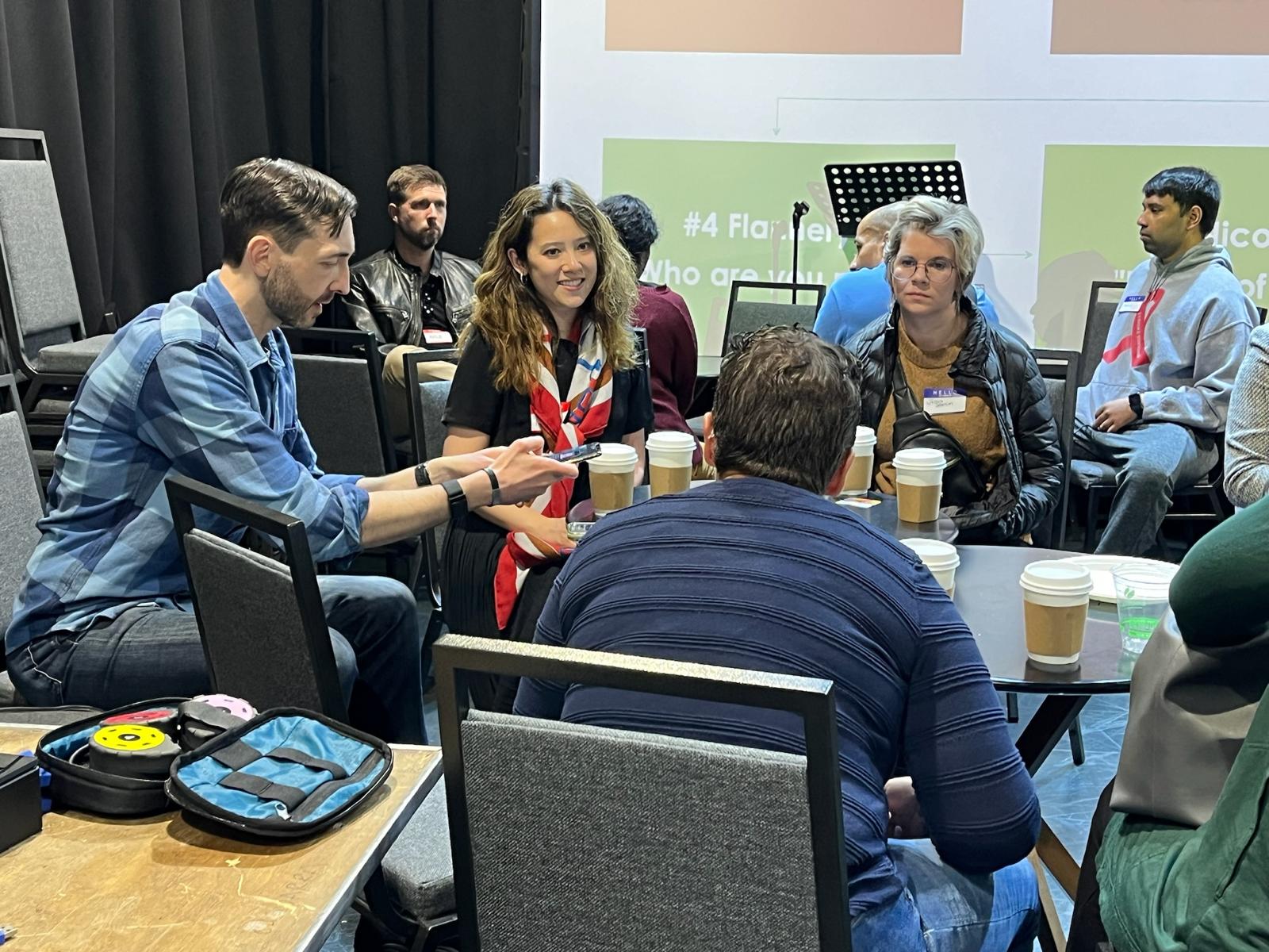 Maddi Listening to Fast Fwd summit participant at a table or other participants